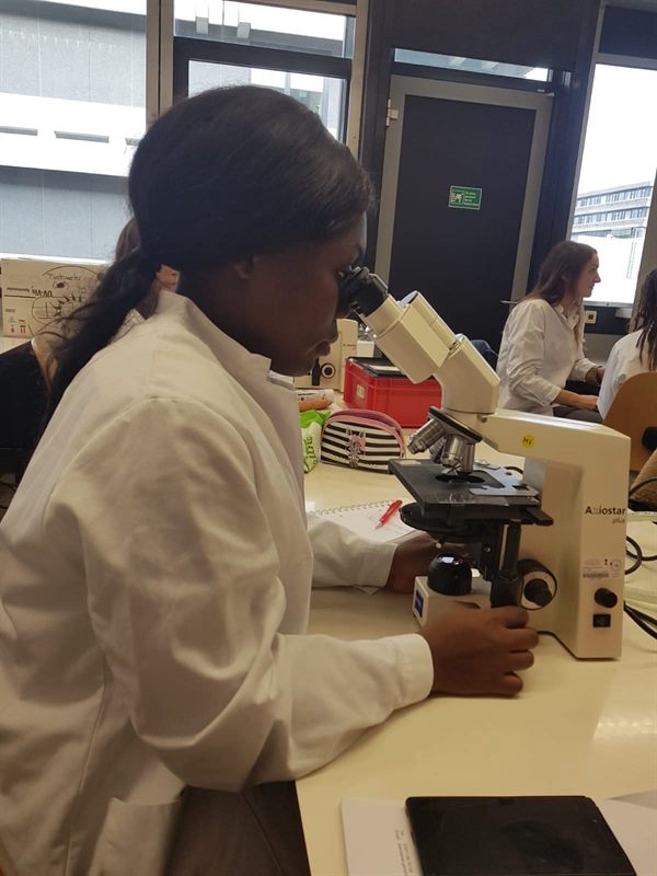 A former ETALL student at a microscope during a practical class in a German laboratory