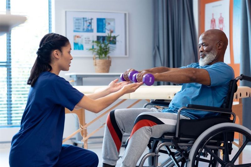 Une kinésithérapeute fait faire des exercices de rééducation à un patient